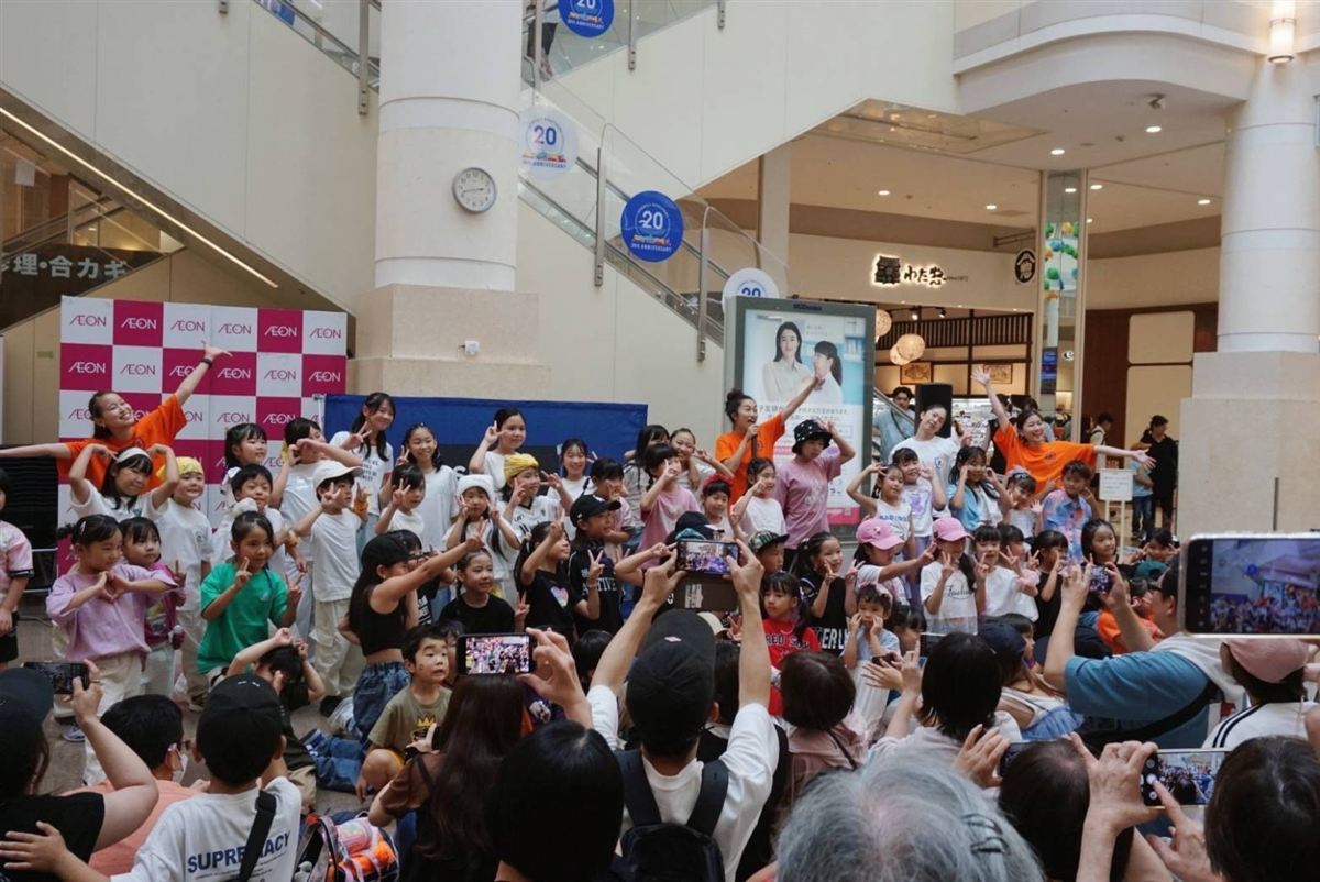 商業施設の吹き抜けで開いたダンスイベントと、撮影する家族
