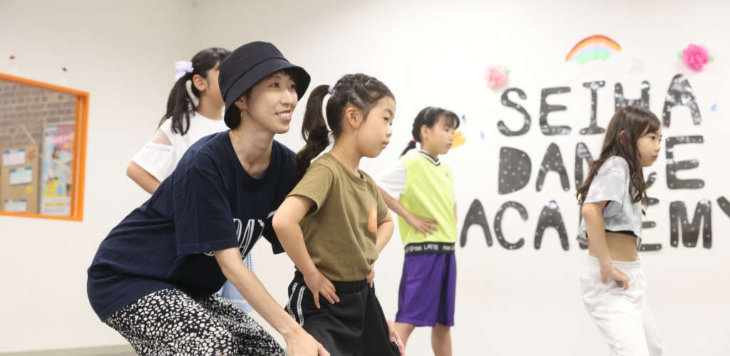 講師が子どもたちの横で一緒に踊りながら教えるレッスン風景